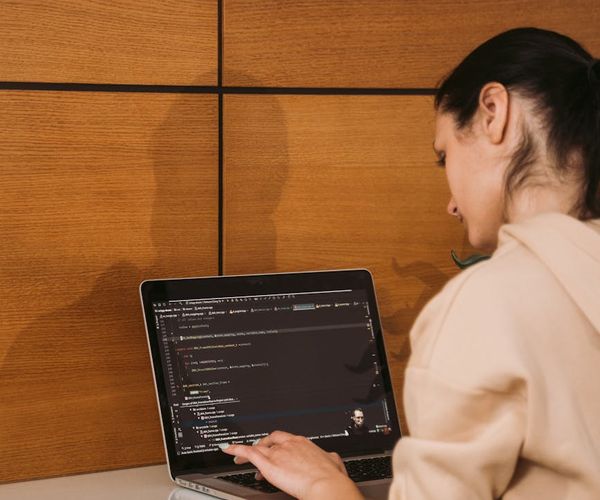 A focused person sitting with a straight back at a modern workspace.